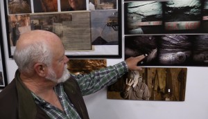 Claude Stamper talking about the mining photos adorning the walls of his office